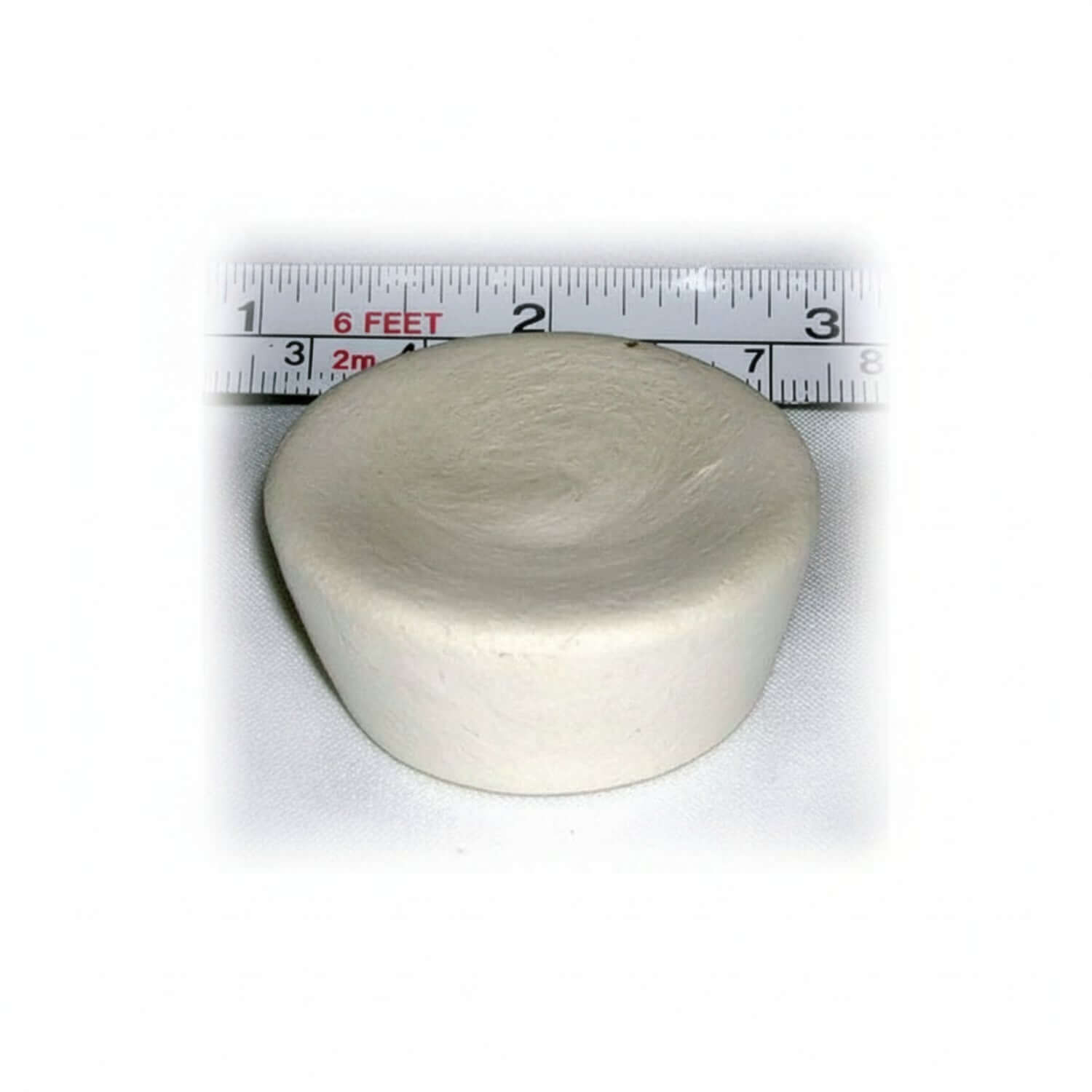 Round ivory cupcake-shaped device with a ruler showing its size on a white background