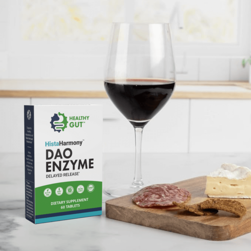 Box of HistaHarmony DAO Enzyme supplement next to a glass of red wine and a charcuterie board.
