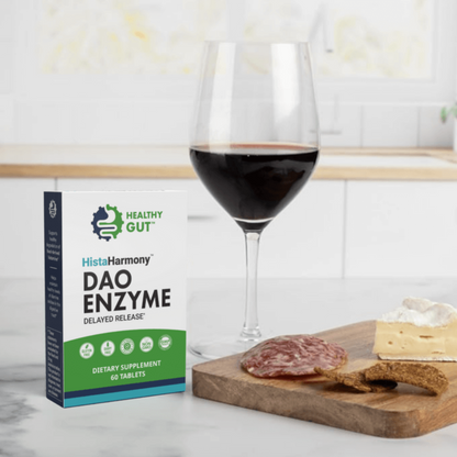 Box of HistaHarmony DAO Enzyme supplement next to a glass of red wine and a charcuterie board.