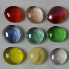 Nine colorful glass balls on a textured surface