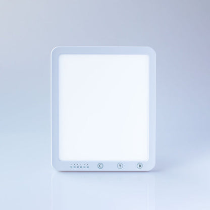 A square white LED light panel with a glowing white face and three control buttons at the bottom, set against a clean light gray studio background.