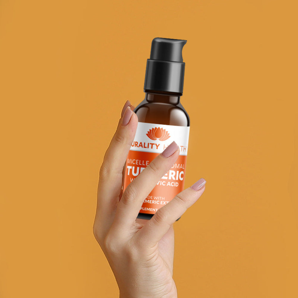 Hand holding a bottle of Turmeric 'Naturality' product against an orange background
