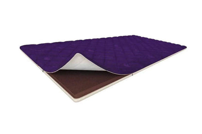 A purple quilted mattress topper or pad shown partially lifted to reveal a brown textured layer underneath, on a plain white background.