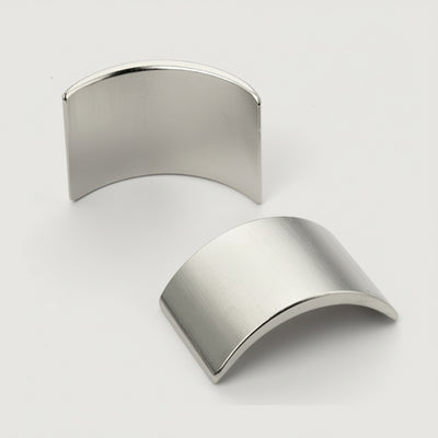 Two metallic  half sphere shapes on a light gray background