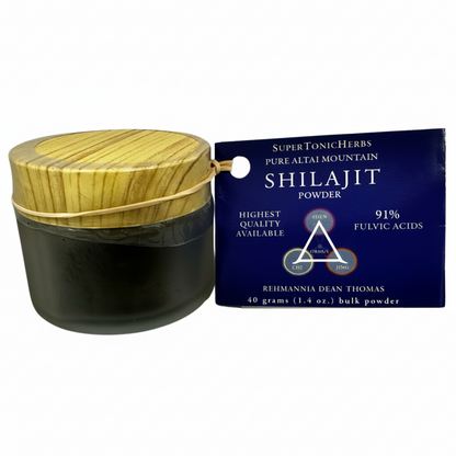 Shilajit powder container with wooden lid and SuperTonic Herbs packaging on a white background