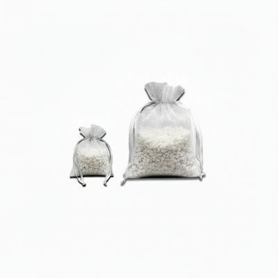 Two white satchels full of small white 'rocks' on a white background
