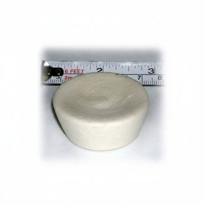 Round ivory cupcake-shaped device with a ruler showing its size on a white background