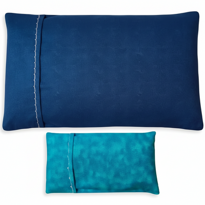 Two blue pillowcases, one lighter, one darker on a white background