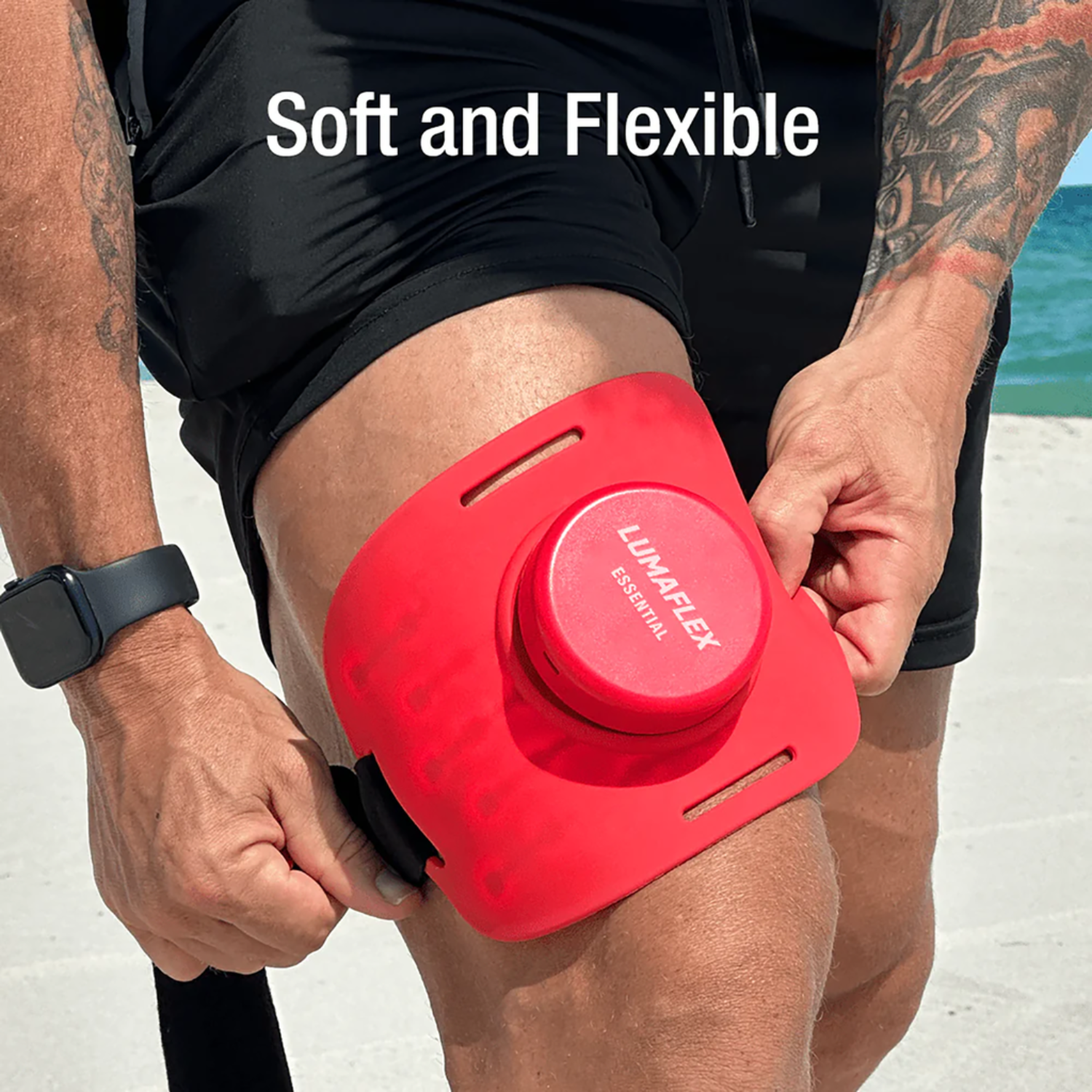 Red knee device being worn on a person's knee with 'Lumaflex' branding, set against a beach background.