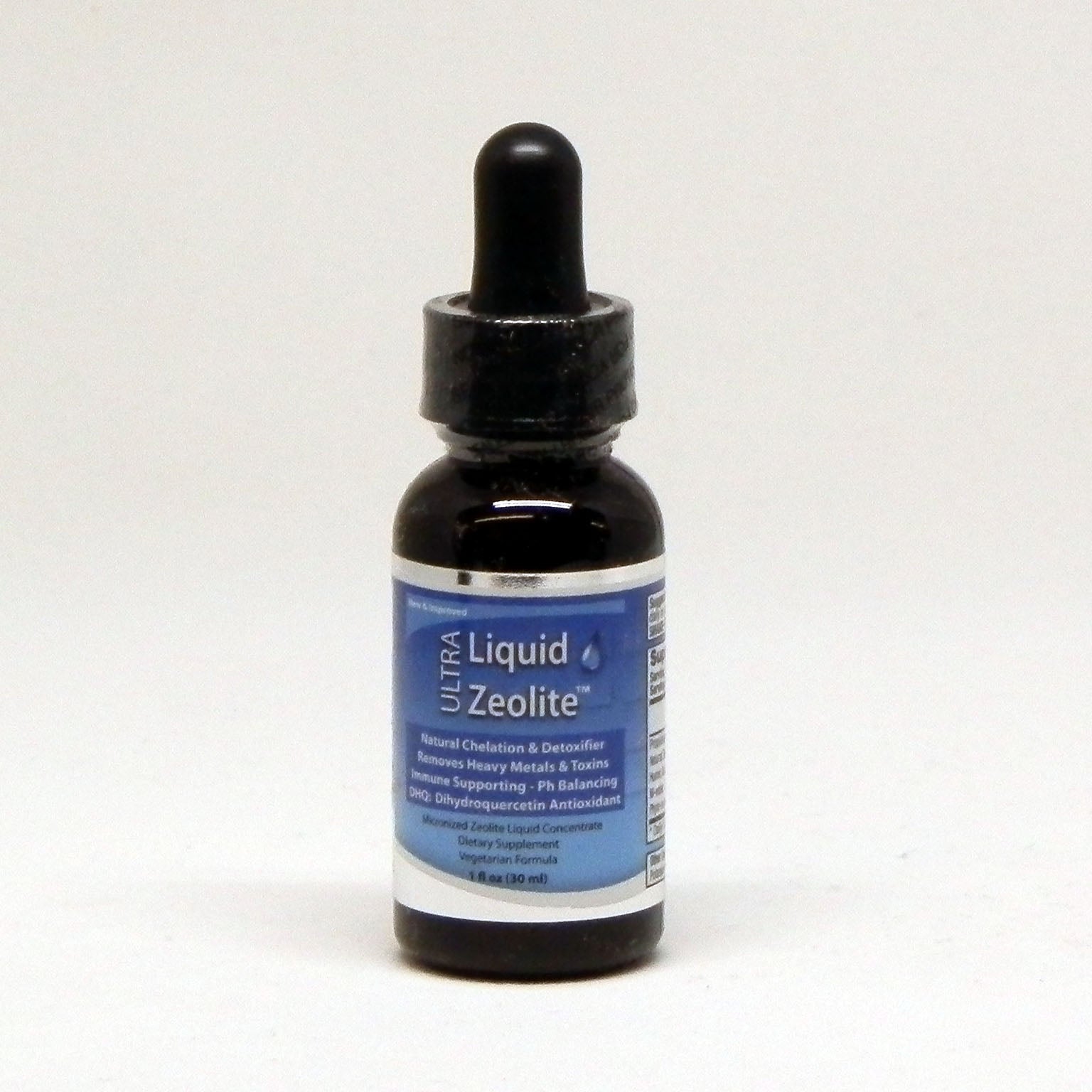 A small dark amber glass dropper bottle of Ultra Liquid Zeolite with a black dropper cap and a blue-and-white label, centered on a plain light background.