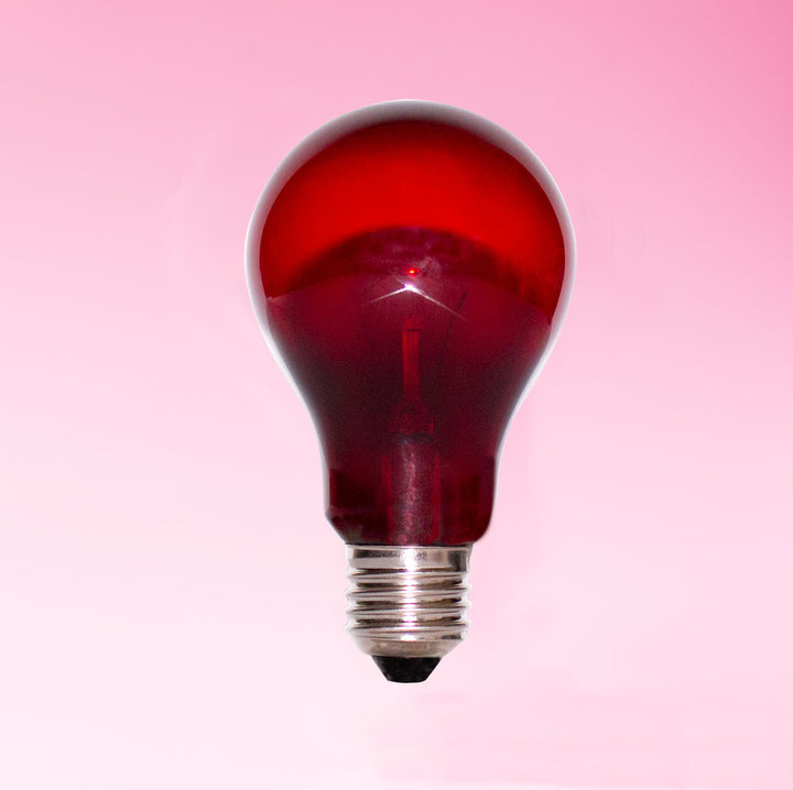 A red translucent light bulb with a silver screw base, centered against a soft pink gradient background.