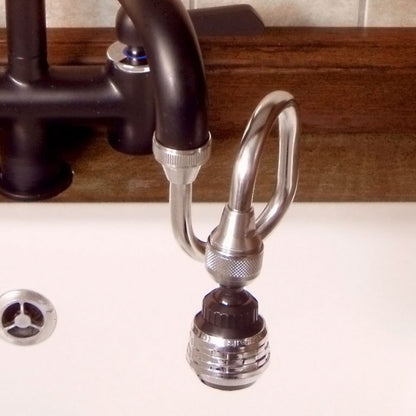 Close-up of a kitchen faucet with a nozzle attachment on a white countertop.