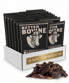 A 30-pack display box filled with Better Bovine beef jerky packets, with a pile of dried beef jerky strips in front on a white background.