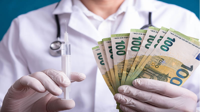 doctor holding vaccine needle and money
