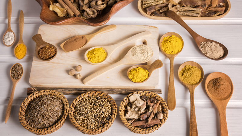top view assorted seeds and spices on wooden spoons and tray