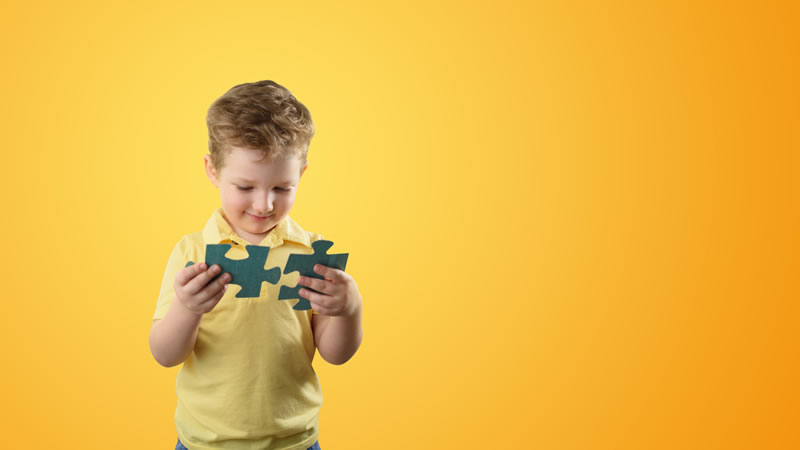 Young boy putting big puzzle pieces together
