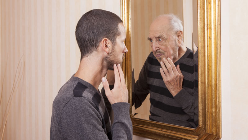 young man looking in mirror at older man